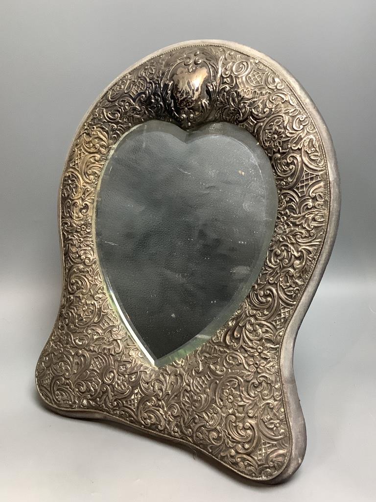 A late Victorian repousse silver mounted easel mirror with heart shaped plate, Henry Matthews, Birmingham, 1893, 35cm.